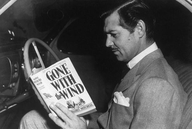 American film star Clark Gable (1901-1960) reading the novel 'Gone With the Wind' by Margaret Mitchell. His greatest role was that of Rhett Butler in the MGM film adaption of the book. (Photo by Hulton Archive/Getty Images)